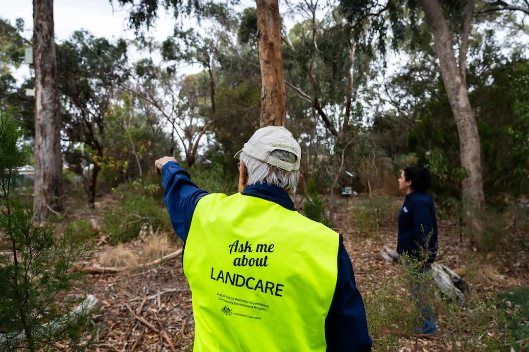 Volunteer looking over the creek, providing information about the biodiveristy